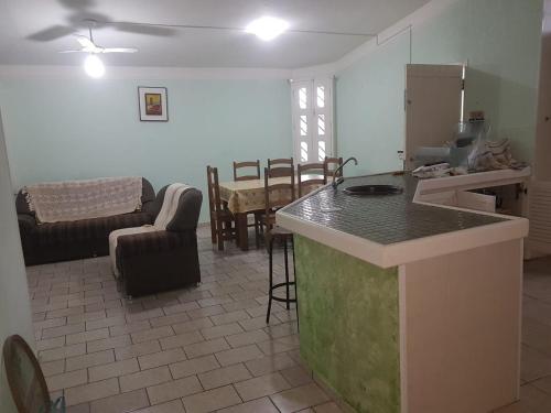 een keuken en een woonkamer met een tafel en een aanrecht bij Casa aBeira Mar 200 metros da praia Peruíbe in Peruíbe