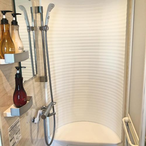 a shower stall with a white venetian blind at La Vista Furano Hills Natural Hot Spring in Furano