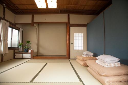a room with two beds in a room with a ceiling at Guest House tokonoma in Shimo-yuge