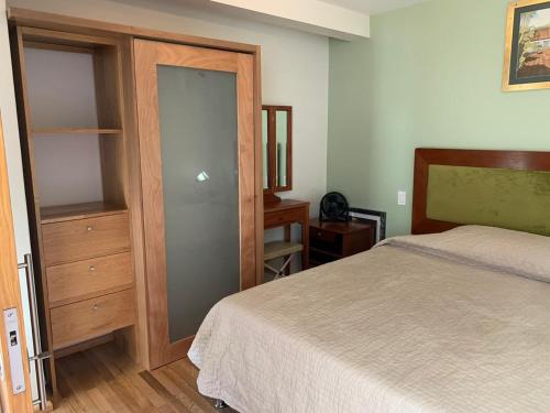 ein Schlafzimmer mit einem Bett, einer Kommode und einem Schrank in der Unterkunft Departamentos Pánuco in Mexiko-Stadt