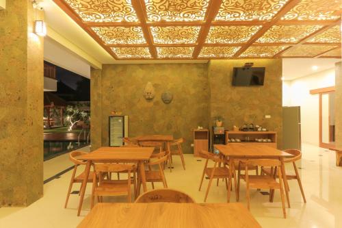 a dining room with wooden tables and a ceiling at Linda Villa 2 in Sanur