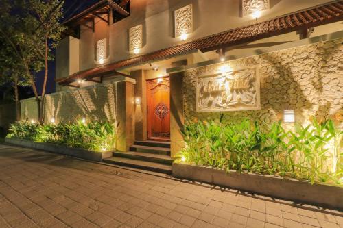 a building with a red door with plants in front of it at Linda Villa 2 in Sanur