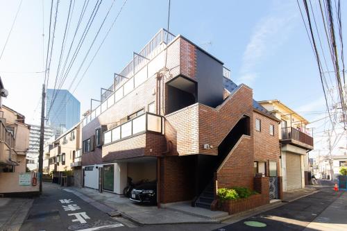 un edificio de ladrillo con una escalera de caracol en una calle en Cross Bridge Ikebukuro, en Tokio