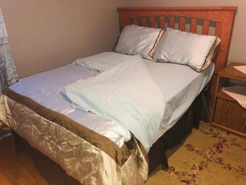 a bed with a wooden headboard and pillows on it at The Paradise @ Lyncott in Lansing