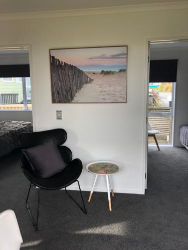 a living room with a chair and a table at Nugget View Kaka Point Motels in Kaka Point