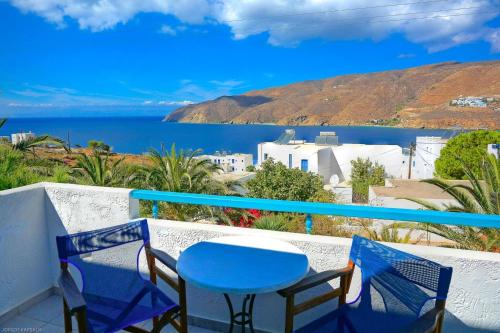 a table and chairs on a balcony with a view of the water at Gryspo's Hotel in Aegiali