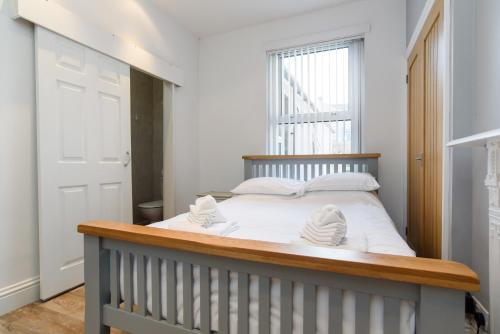 una camera da letto con un letto con lenzuola bianche e una finestra di Handpost Heights a Newport