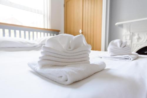 un mucchio di asciugamani seduti sopra un letto di Handpost Heights a Newport