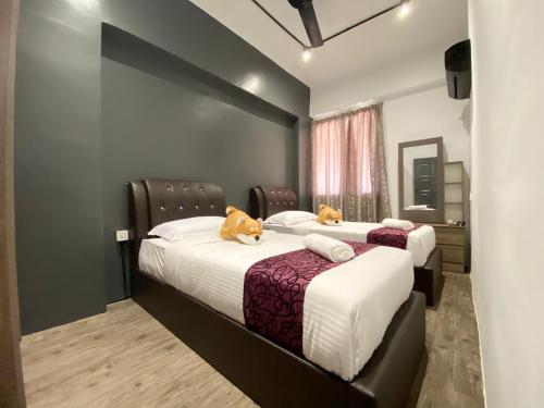 two beds in a hotel room with cats on them at Century Suria Aparment Langkawi by Zervin in Kuah