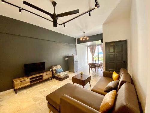 a living room with a couch and a flat screen tv at Century Suria Aparment Langkawi by Zervin in Kuah