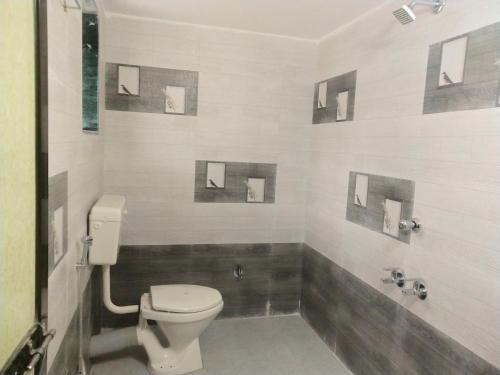 a bathroom with a toilet and a shower at Hotel Rosary House in Malvan