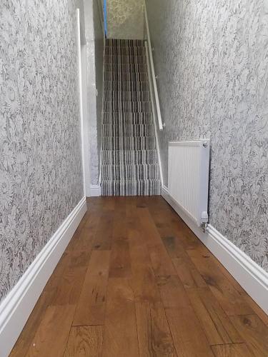 an empty hallway with a staircase and wood floors at The Old Nags Head in Bishop Auckland