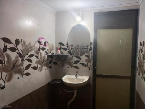 a bathroom with a sink and a mirror at Hotel Rosary House in Malvan