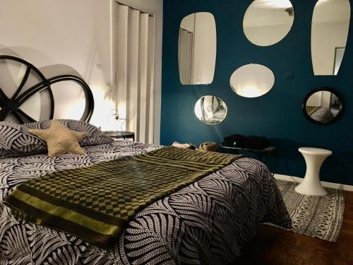 a bedroom with a bed with mirrors on the wall at Appartement au cœur de Saint Gaudens in Saint-Gaudens