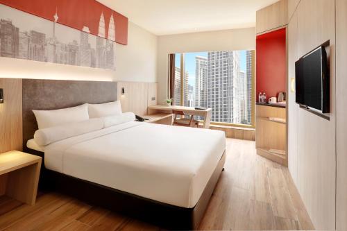 a hotel room with a white bed and a television at ibis Kuala Lumpur City Centre in Kuala Lumpur