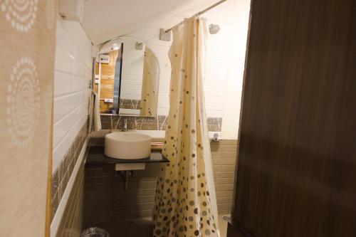 a bathroom with a sink and a shower curtain at Mrugavani Resort & Spa in Hyderabad