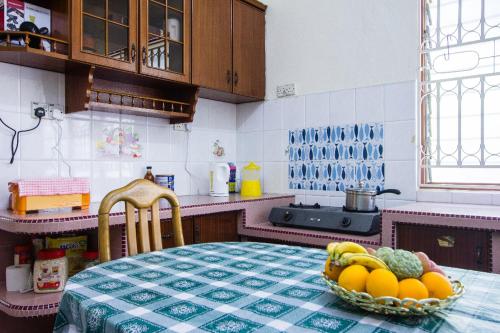 a kitchen with a table with a bowl of fruit on it at Sweet Home With 2 Auto Gates at BM, Penang, M'sia in Bukit Mertajam