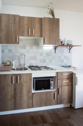 a kitchen with wooden cabinets and a sink at Apartments PODATOK 4 in Primošten