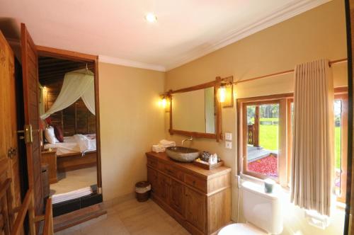 a bathroom with a sink and a mirror at Pondok Sebatu Eco Lodge in Tegalalang