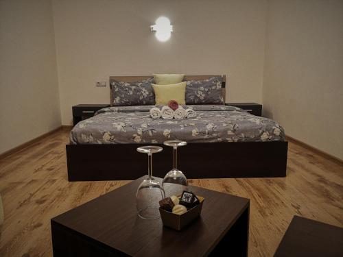 a bedroom with a large bed and a table at Kalniečiai park apartment in Kaunas