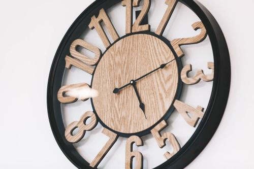a black and wooden clock with dollar signs on it at Sound Gallery House - SHA Plus in Phuket Town