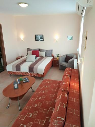 a hotel room with a bed and a couch at Yellow Apartmanház in Bük