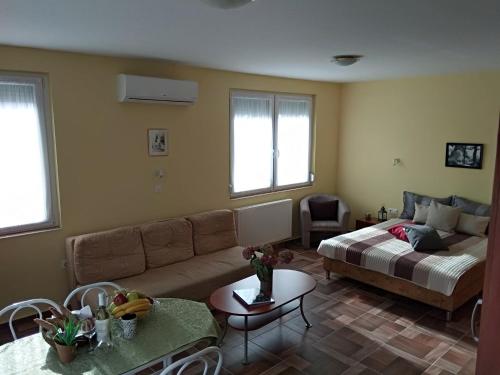 a living room with a couch and a bed at Yellow Apartmanház in Bük