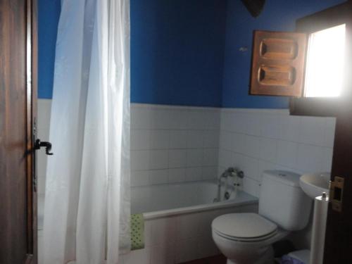 a bathroom with a toilet and a tub and a sink at Hostal Venta Liara in Allepuz