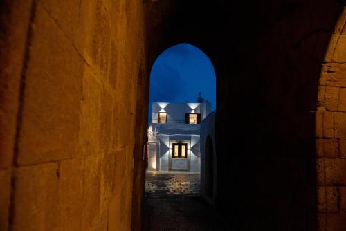 an alleyway with a white house at night at IN Lindos in Líndos
