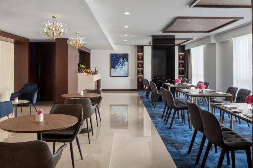 a restaurant with tables and chairs in a room at Pullman Dubai Creek City Centre in Dubai