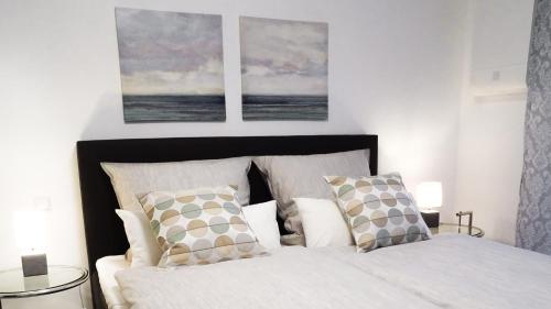Boland Apartments في روست: غرفة نوم بسرير مع صورتين على الحائط