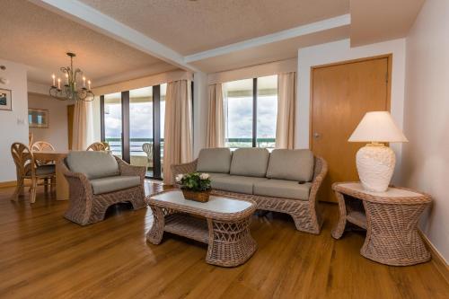 a living room with a couch and chairs and a table at Alupang Beach Tower in Tamuning