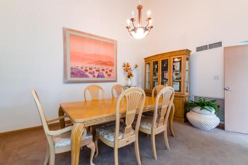 a dining room with a wooden table and chairs at Alupang Beach Tower in Tamuning