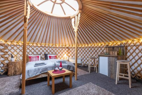 a bedroom in a yurt with a bed and a table at Yurt District in Rovaniemi