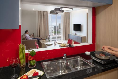 a kitchen with a sink and a red wall at Mercure Hai Phong in Hai Phong