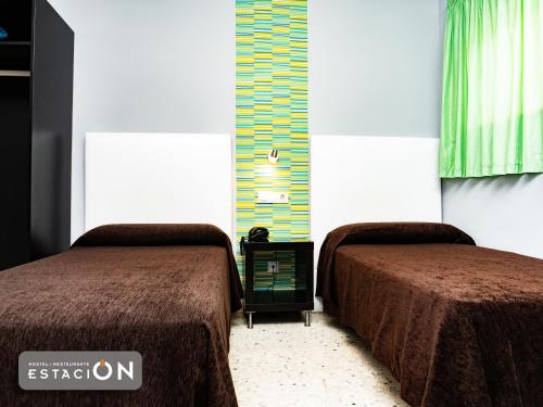 two beds sitting next to each other in a room at Hostal Restaurante EstaciÓN in Jaén