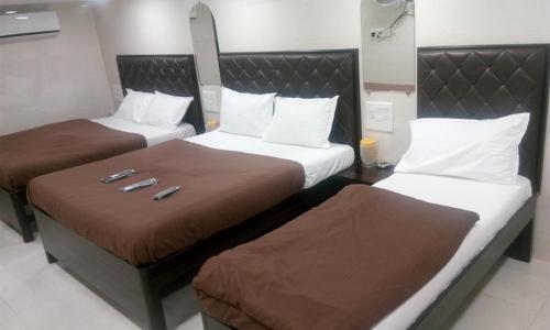 Hotel Qamar في مومباي: سريرين في غرفة فندق بسريرين