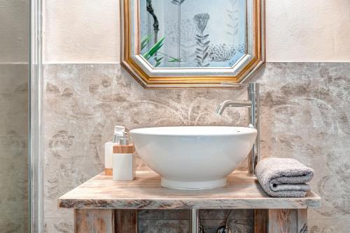 a bathroom with a white bowl sink on a wooden table at Casa Rowe B&B in Pistoia