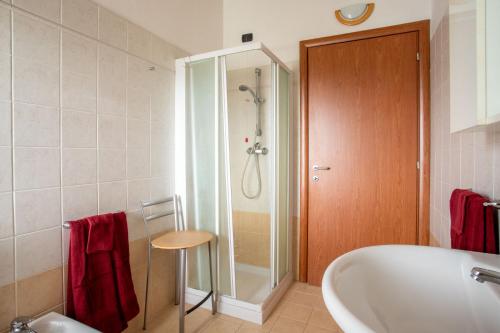 bagno con vasca, doccia e asciugamani rossi di Casa Vacanze Valeria a Sondrio