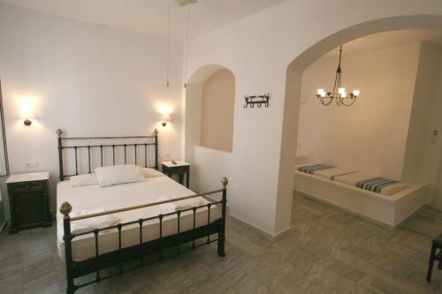 a bedroom with a bed and a tub in it at Panorama Hotel in Naxos Chora