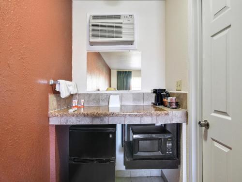a small kitchen with a counter and a microwave at Route 66 Inn in Shamrock