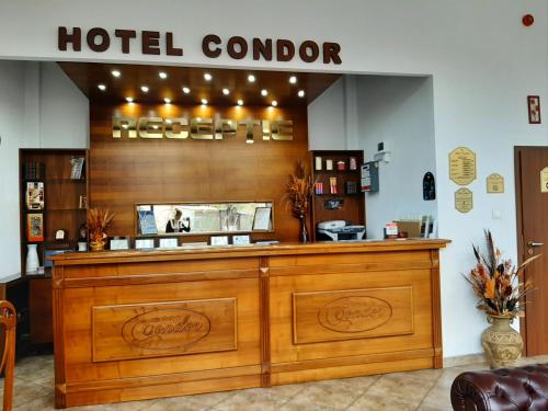 a hotel lobby with a large wooden reception desk at Hotel Condor in Oraviţa