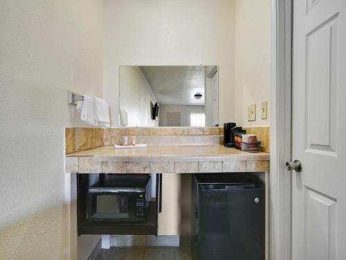 a bathroom counter with a sink and a mirror at Route 66 Inn in Shamrock