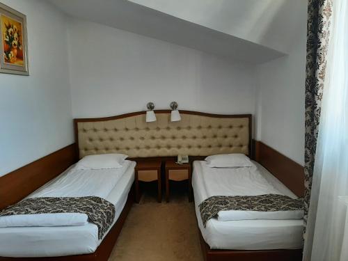a room with two beds and a table in it at Hotel Condor in Oraviţa