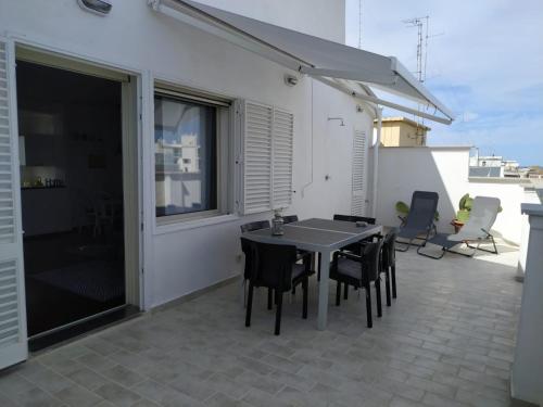 a patio with a table and chairs on a balcony at Michi's Home - Attico in Centro in Bari