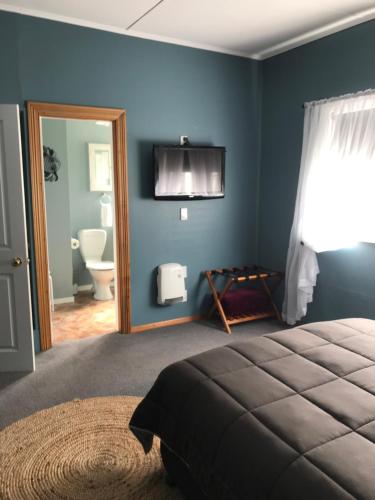 1 dormitorio con cama, espejo y baño en Admirals Lodge, en Picton