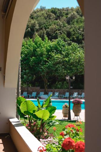 a view of a swimming pool with chairs and flowers at Anemolia Parga Suites in Sarakiniko