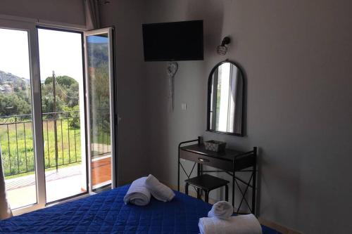 a bedroom with a bed and a mirror and a window at Rodanthy II in Katelios