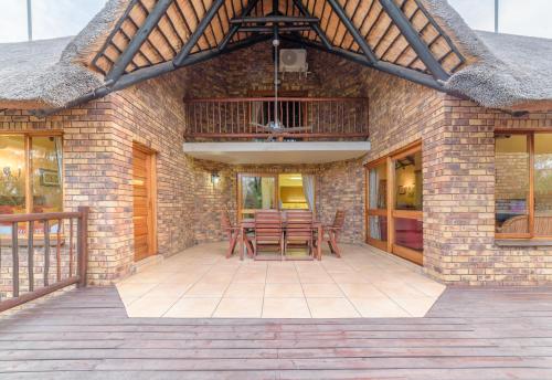 a patio with tables and chairs on a brick building at Kruger Park Lodge Unit No. 524 in Hazyview
