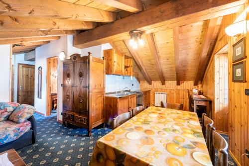 a kitchen with a table in a room with wooden ceilings at Santa San in Champoluc